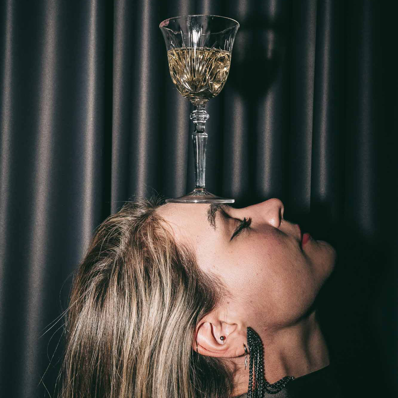 Woman with glass of LVST & FEAST balancing on head